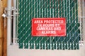 Signboard `Area protected 24 hours by cameras and alarms` on closed by lock gates