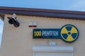 Signboard on bar entrance with yellow and black radiation hazard emblem, inscription in russian `100 x-ray` and dummy rocket