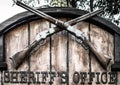 Signboard `Sheriff`s Office` with two old crossed lever rifles.