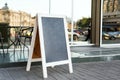 Signboard on the street. Empty menu board stand. Restaurant sidewalk chalkboard sign board. Freestanding A-frame blackboard near