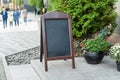 Signboard on the street. Empty menu board stand. Restaurant sidewalk chalkboard sign board. Freestanding A-frame blackboard near