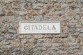 Signboard with the text Citadela on a stone wall in the Old Town of Budva