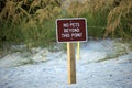 Signboard with warning about no pets beyond this point on seaside beach with small sand dunes and grassy vegetation on Royalty Free Stock Photo