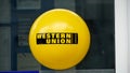 A signboard of Western Union with it`s logo on the door of a bank