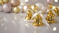 Golden Christmas Bells With White Ribbon. Elegant Holiday Decor On Glossy Surface With Ornaments. Festive Background With Light R Royalty Free Stock Photo