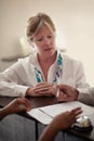 Signing the check in sheet. a senior woman checking in at the hotel. Royalty Free Stock Photo