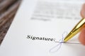 Signing a contract with signature with gold pen macro close-up, businessman,contract,deal,concept background Royalty Free Stock Photo