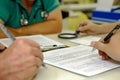 signing medical document, focus on female hands, putting signature at official paper, Royalty Free Stock Photo