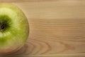 Single green apple on a wooden background