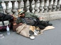 Homeless tramp on a street of Paris with a cat and a dog