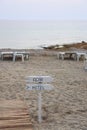 Signpost on the beach against the background of the sea and empty sunbeds, Alanya, Turkey, April 2021 Royalty Free Stock Photo