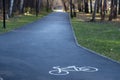 A signpost or bicycle road sign painted on the asphalt in a city park. Royalty Free Stock Photo