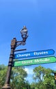 signpost with classic lights under blue sky