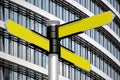 Yellow signpost with three arrows, office building in background Royalty Free Stock Photo
