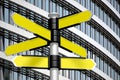 Yellow signpost with five arrows, office building in background Royalty Free Stock Photo