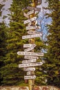 Signpost in Healy Alaska with distances to Magic Bus Nome Seward Sarah Palins House Anchorage and more- Evergreen trees in Royalty Free Stock Photo