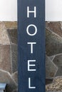 Signpost HOTEL near the facade of the entrance group of the building, Close-up, vertical