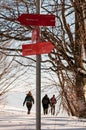 Signpost indicating the direction to peak of Slivnica and the town of Cerknica in Slovenia and hikers