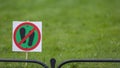 Signpost on the lawn does not walk on a background of lush green grass. close-up. copy space.Soft focus. blur Royalty Free Stock Photo