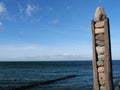 Signpost made of wood and stones at the pier in Zingst on the DarÃ and a view of the Baltic Sea