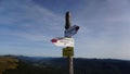 Signpost pointing towards different destinations with beautiful mountains in the background