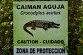 Signpost saying beware of crocodiles, caymans, in spanish at the caribbean coast