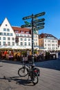 Signpost to tourist sights in Tallinn with Bicycle at base in Raekoja Plats Town Hall Square in Tallinn, Estonia