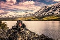 Signpost for Trail in front of a lake and snowy mountains in Norway