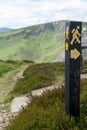 Signpost of a walking man with a backpack with directional arrow point the correct direction of a trail Royalty Free Stock Photo