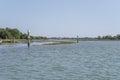 signposts draw a canal among saltmarshes at lagoon, Grado, Friuli, Italy