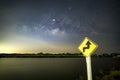 Signs, signs, beware of curves at night, behind the sign with the Milky Way. Royalty Free Stock Photo