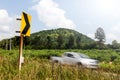 Signs curve with cars blurred hill.