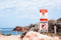 Signs `Danger` and `Taking shellfish prohibited` on a beach