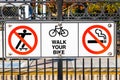 Signs depicting the No Skateboarding, no Smoking and Walk your bike rules posted at a train station