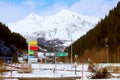 Signs of gas station beside highway in front of snow covered mountains at south side of the Alp, Switzerland Royalty Free Stock Photo