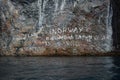 Signs on the rocks of Geiranger fiord coast