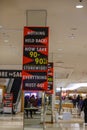 Signs for a storewide bankruptcy sale hanging from the ceiling in a nearly empty store with several customers