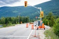 Signs and trafic lights at a construction site along a highway in the mountains