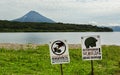 Signs warn of the danger of meeting tourists with bears on background of Kurile Lake and Ilyinsky volcano.