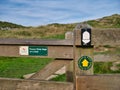 Signs on a weathered wooden gatepost show the way of Hadrian`s Wall Path in the Northumberland National Park, UK. Royalty Free Stock Photo