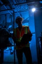 Sihouette of industrial scene lit blue with worker around pipes ,gauges and valves. Royalty Free Stock Photo