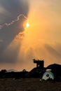 Silhouette of life lifeguard tower and camping tent on outdoor beach with dramatic sky