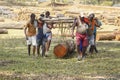 Two people are keeping wooden logs on their shoulders,going to load in carrier.