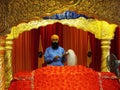A Sikh at the altar with the Holy Book in the main prayer hall of the Guru Nanak Darbar Tatt Khalsa Diwan Gurdwara Sikh Temple. Ku