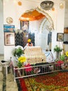 A sikh priest is reading his holy book inside an old gurudwara