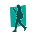 Silhouette of a female student reading a book while walking.