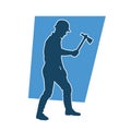 Silhouette of a worker in action pose using his axe tool. Royalty Free Stock Photo