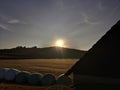 Silage bales and barn roof in atmospheric rural sunrise scenery Royalty Free Stock Photo