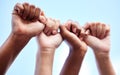 Silence encourages the tormentor. an unrecognisable group of women raising their hands in strength outside.