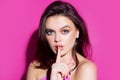 Silence. Woman silence or secrecy with finger on lips hush hand gesture on pink background. Pretty girl placing fingers Royalty Free Stock Photo